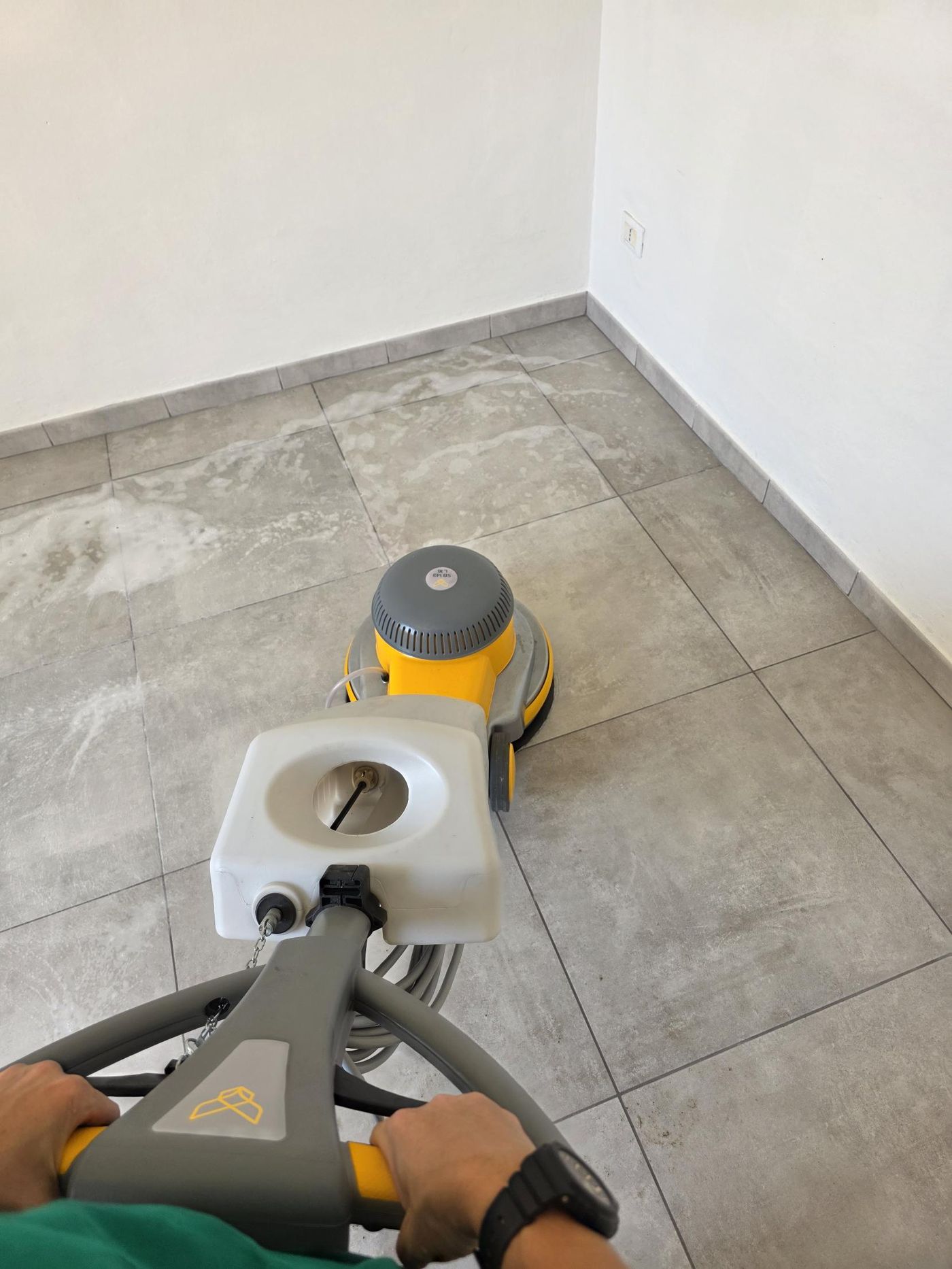 Operatrice al lavoro con la monospazzola su un pavimento in gres